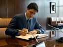 Le Premier ministre canadien Justin Trudeau signe un livre d'or lors d'une rencontre avec le secrétaire général de l'ONU Antonio Guterres au siège de l'ONU à New York le 21 juillet 2023.