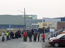 Des personnes sans véhicule font la queue pour s'inscrire à un vol d'évacuation vers Calgary en raison de l'approche d'un incendie de forêt, à Yellowknife le jeudi 17 août 2023.