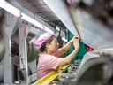 Une femme travaille dans une usine textile de la ville de Haian, dans la province orientale du Jiangsu.  La Chine a connu une série de ratés sur les données économiques après être sortie de l'une des plus longues répressions du COVID-19 au monde.