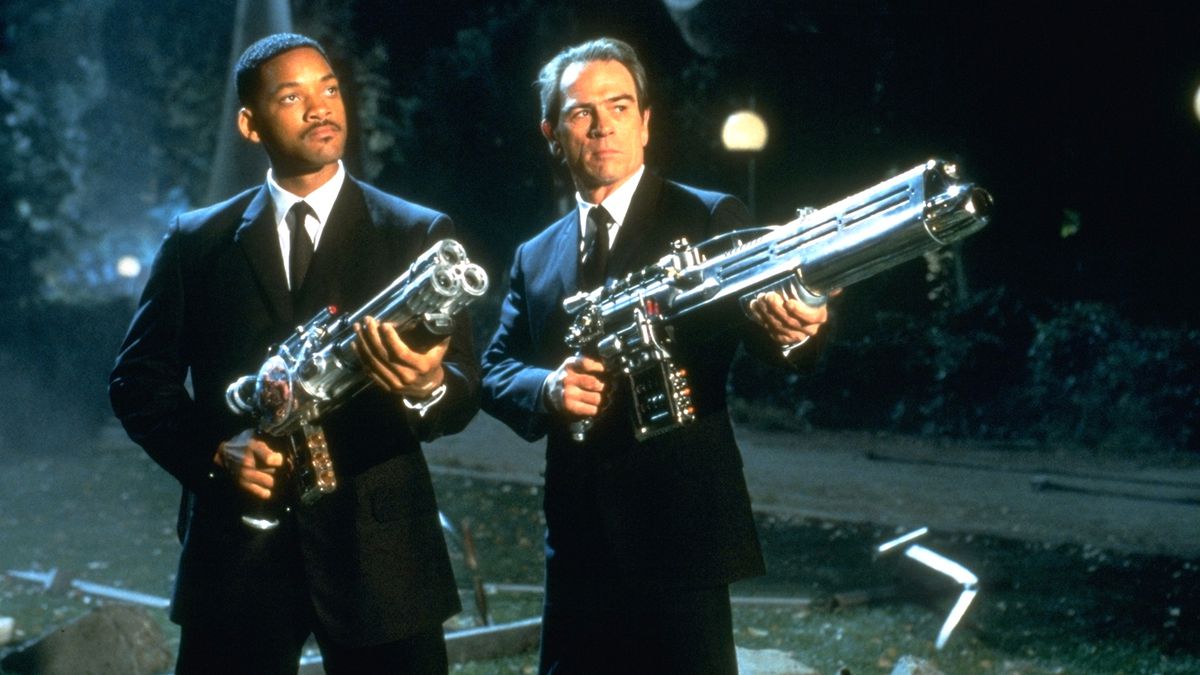 (De gauche à droite) Will Smith et Tommy Lee Jones dans le rôle des agents J et K tenant de grands fusils spatiaux de couleur chromée dans Men in Black.