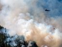 Un hélicoptère bombardier d'eau survole l'incendie de forêt de Cameron Bluffs, près de Port Alberni, en Colombie-Britannique.