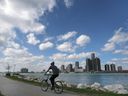 DOSSIER – Un cycliste est montré le long de la rivière Détroit à Windsor, en Ontario, alors que l'horizon de Détroit, au Michigan, est affiché en arrière-plan le mercredi 13 octobre 2021.