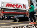 Des travailleurs vus en grève devant une épicerie Metro à Toronto.