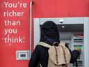 Un client utilise le guichet automatique de la Banque de Nouvelle-Écosse à Toronto.  Les banques canadiennes commencent à publier leurs résultats cette semaine.