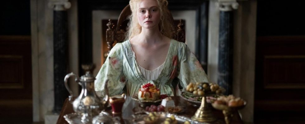 Elle Fanning sitting behind a table looking very sad in The Great.