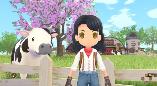 Story of Seasons: A Wonderful Life - a player stands in front of a while fenced cow pasture where a spotted cow stands in front of a barn