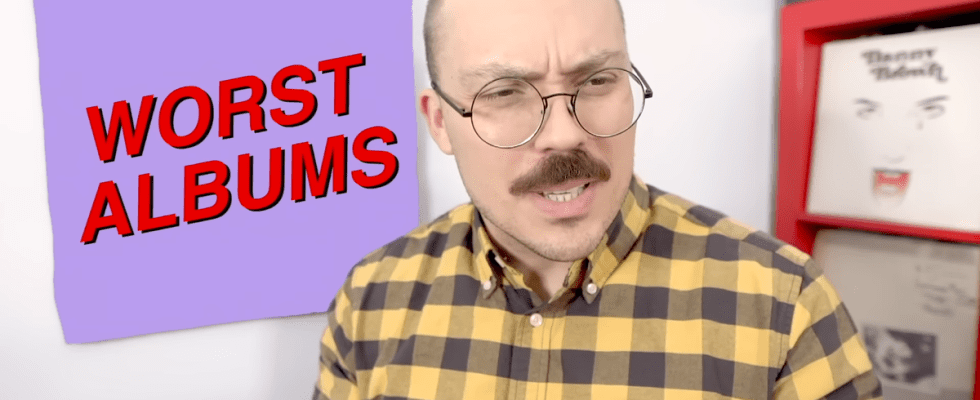 Anthony Fantano looks quizzical in front of a square reading