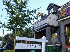 Une pancarte À vendre est affichée devant une maison dans le quartier de Riverdale à Toronto.