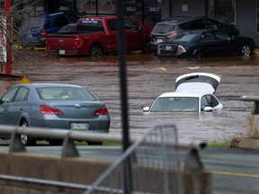 Des voitures abandonnées dans le stationnement d'un centre commercial sont vues dans les eaux de crue à Halifax.