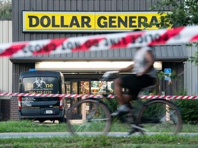 Un cycliste passe devant le magasin Dollar General où trois personnes ont été tuées par balle la veille, le 27 août 2023, à Jacksonville, en Floride.