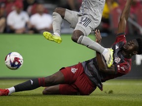 Le défenseur du Toronto FC Aimé Mabika (6) glisse des tacles alors que le milieu de terrain du CF Montréal Kwadwo Opoku saute vers le ballon lors de la première mi-temps de l'action de soccer de la MLS à Toronto le dimanche 20 août 2023.