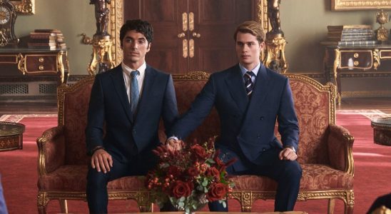 Alex and Henry sitting together holding hands looking during a meeting with the King of England.