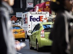 Un véhicule de FedEx Corp. est stationné alors que des taxis passent dans le quartier Midtown de New York.