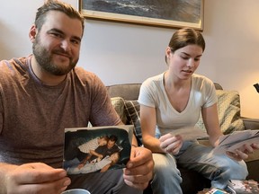 Robie et Sophie Holland passent en revue des photos d'eux-mêmes avec leur père, décédé lors des récentes inondations intérieures en Nouvelle-Écosse, à Tantallon, en Nouvelle-Écosse, le vendredi 11 août 2023.