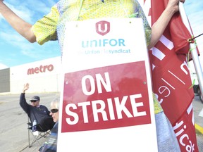 Les employés en grève de l'épicerie Metro Inc. de la section locale 414 d'Unifor tiennent des lignes de piquetage à Toronto.