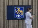 Un piéton passe devant la signalisation de la Banque Royale du Canada à Brampton, en Ontario.
