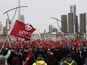 Des partisans d'Unifor, le syndicat national représentant les travailleurs de l'automobile, assistent à un rassemblement devant le siège social de General Motors, en arrière-plan, à Windsor, en Ontario, le vendredi 11 janvier 2019.