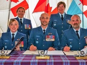 Le lieutenant-colonel.  Whitney Camm, à gauche, est accompagnée du colonel Leif Dahl, commandant de la 8e Escadre, au centre, alors qu'elle prend le commandement du 8e Escadron de soutien aux opérations, succédant au lieutenant-colonel.  Adam Pentney, à droite, lors d'une cérémonie de signature à la 8e Escadre Trenton, le 6 juillet 2023.