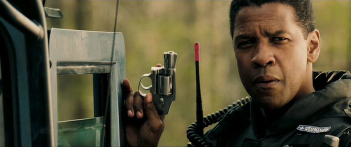 Denzel Washington dans le rôle de Doug Carlin tenant un revolver dans Deja Vu.