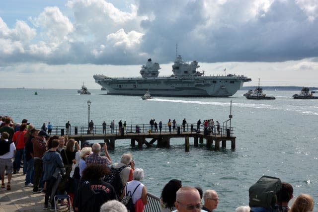 Les familles et les sympathisants saluent le porte-avions de la Royal Navy HMS Prince of Wales alors qu'il quitte la base navale de Portsmouth
