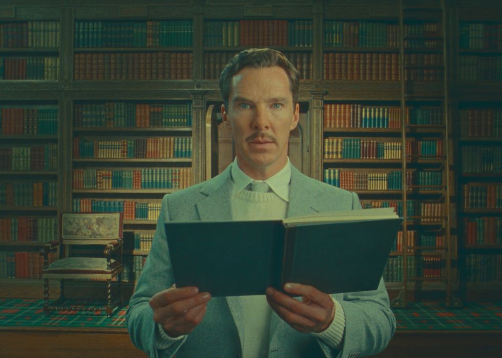 Benedict Cumberbatch pose dans une photo de production pour la merveilleuse histoire d'Henry Sugar sur Netflix, regardant vers la caméra et tenant un livre ouvert
