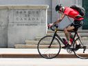 Un cycliste passe devant la Banque du Canada à Ottawa le mardi 11 juillet 2023. 