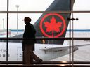 Un voyageur dépasse un avion d'Air Canada à l'aéroport international de Calgary.