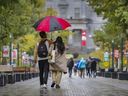 Un couple partage un parapluie en marchant sur le campus de l’Université McGill.