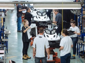 Travailleurs et étudiants à la chaîne de fabrication de la motoneige BRP Tundra à l'usine d'assemblage de l'entreprise à Valcourt, au Québec.