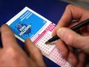 Un parieur remplit un billet de la Loterie nationale le 7 février 2008 à Londres.