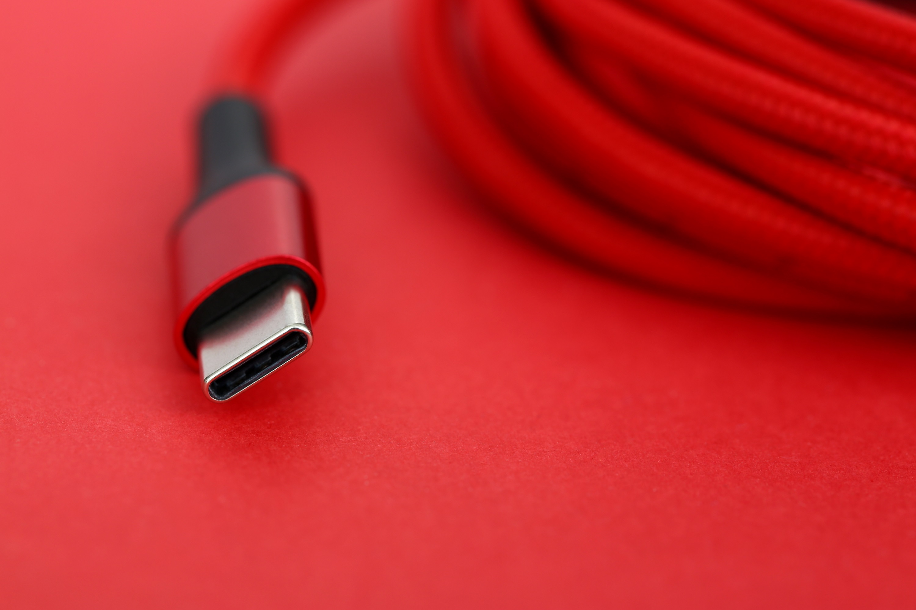 Extrémité du câble USB rouge posée sur la table en gros plan extrême