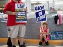 Un jeune sympathisant tient une pancarte alors que les membres de United Auto Workers font grève dans une usine d'assemblage Ford à Wayne, Michigan. 