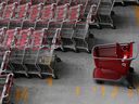 Un panier Target se trouve parmi d'autres chariots dans un parking à l'extérieur du magasin Target de Harlem à New York. 