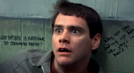 Jim Carrey backed against a bathroom wall with a look of horror in Dumb and Dumber.