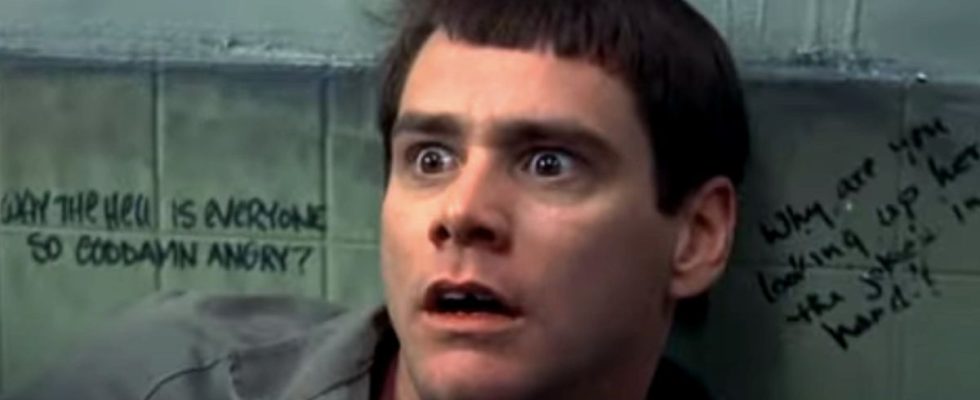 Jim Carrey backed against a bathroom wall with a look of horror in Dumb and Dumber.