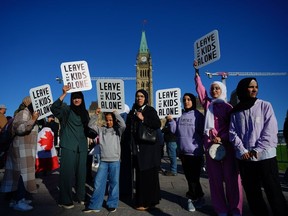 Des gens brandissent des pancartes lors d'une manifestation sur la Colline du Parlement à Ottawa le mercredi 20 septembre 2023. Des manifestations et contre-manifestations pour et contre la communauté trans et LGBTQ du Canada sont prévues mercredi partout au Canada.