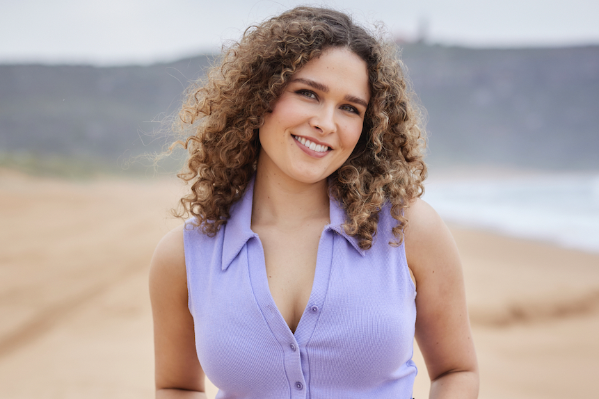 Ally Harris dans le rôle de Dana à la maison et à l'extérieur, posant dans un débardeur violet clair et un jean sur la plage