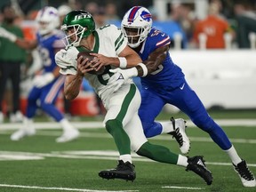 Le quart-arrière des Jets de New York Aaron Rodgers (8) est limogé par l'ailier défensif des Buffalo Bills Leonard Floyd (56) au cours du premier quart d'un match de football de la NFL, le lundi 11 septembre 2023, à East Rutherford, NJ