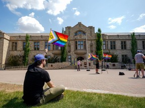 Une personne tient un drapeau de la fierté lors d'une cérémonie de lever du drapeau de la fierté à Saskatoon le jeudi 1er juin 2023. Un juge de la Saskatchewan doit entendre aujourd'hui une demande d'injonction visant à mettre fin à la politique provinciale des pronoms affectant les enfants à l'école.