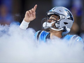 Le quart-arrière des Carolina Panthers, Bryce Young, montre le ciel alors qu'il entre sur le terrain avant un match de football préparatoire de la NFL contre les Lions de Détroit, le vendredi 25 août 2023, à Charlotte, Caroline du Nord.