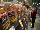 Loaves of Canada Bread Co. Ltd. Les pains multigrains Dempster's sont exposés à la vente alors qu'un employé remplit les étagères d'une épicerie de Vancouver. 