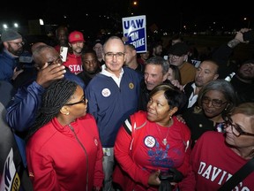 Le président de l'United Auto Workers, Shawn Fain, se tient aux côtés des membres de l'UAW en grève à l'usine d'assemblage Ford du Michigan à Wayne, Michigan, tôt le vendredi 15 septembre 2023.