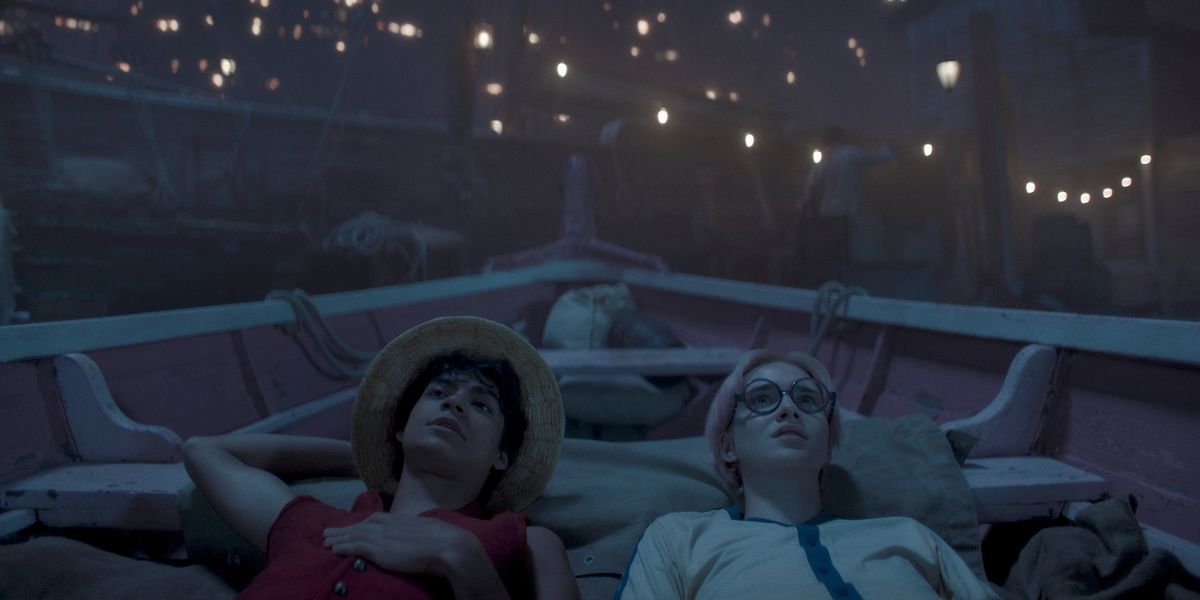 Luffy (Iñaki Godoy) et Koby (Morgan Davies) allongés dans un bateau regardant les étoiles