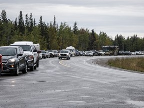 Des véhicules font la queue pour faire le plein à Fort Providence, dans les Territoires du Nord-Ouest, sur la seule route au sud de Yellowknife, le jeudi 17 août 2023. Des milliers de véhicules devraient se rendre à Yellowknife dans les prochains jours alors qu'un ordre d'évacuation de trois semaines est prévu. lever à midi.