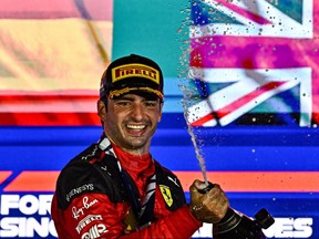 Le pilote espagnol de Ferrari Carlos Sainz Jr pulvérise du champagne