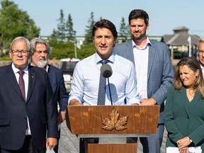 Le ministre canadien du Logement, Sean Fraser, se tient derrière le premier ministre Justin Trudeau lors d'une conférence de presse à l'Île-du-Prince-Édouard en août.