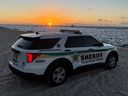 Véhicule de police du bureau du shérif du comté de Palm Beach sur la plage au coucher du soleil.