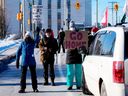 Des résidents participent à une contre-manifestation pour empêcher les véhicules de circuler dans un convoi en route vers la Colline du Parlement, le 17e jour d'une manifestation contre les mesures liées à la COVID-19 qui s'est transformée en une manifestation antigouvernementale plus large, à Ottawa, dimanche 2 février. 13, 2022.