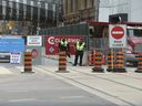 En direction est et ouest, le long du corridor de construction qui fermera les rues Queen Est et Ouest pendant les quatre prochaines années et demie pour permettre la construction d'une section du projet de métro de la ligne Ontario le mardi 16 mai 2023. est uniquement ouvert à la circulation piétonne. 