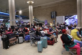 Des passagers attendent à l'aéroport Ben Gourion près de Tel Aviv, en Israël, le 7 octobre 2023, alors que les vols sont annulés en raison de l'attaque surprise du Hamas.